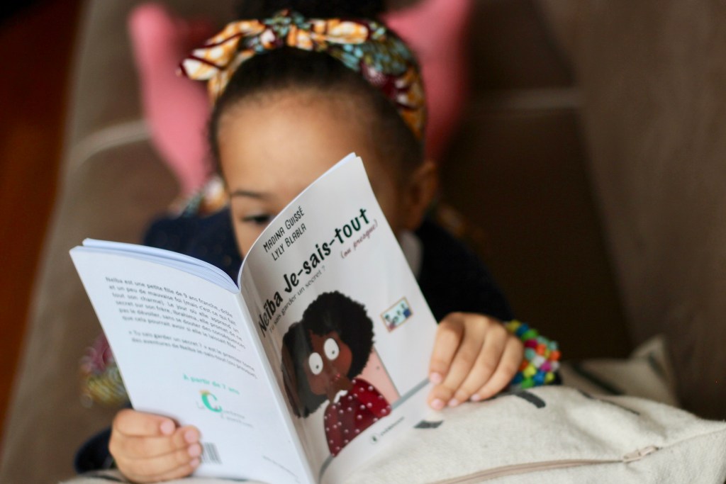 Une petite fille lisant "Neïba Je sais tout"